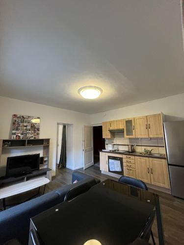 un salon avec un canapé et une cuisine dans l'établissement Au relais de la gare, à Quimper