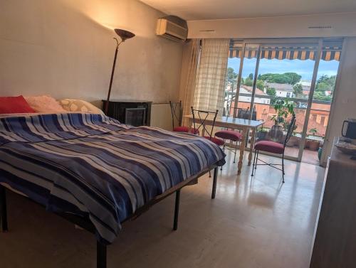 une chambre avec un lit, une table et des chaises dans l'établissement 4 people, 15 minutes from Cannes, au Cannet