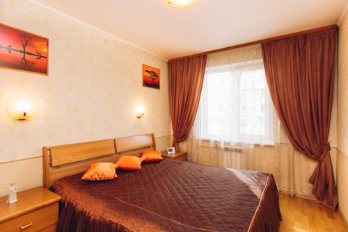 エカテリンブルクにあるApartment Na Kuznechnoyのベッドルーム1室(オレンジ色の枕と窓付)