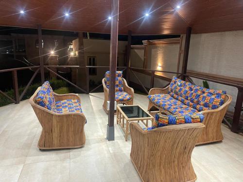 a group of chairs and tables on a balcony at Whispering Hearts Guest House in Bortianor