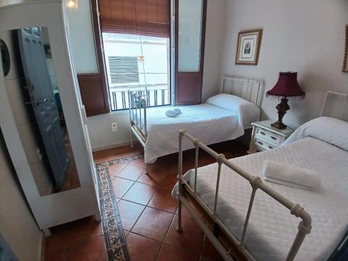 a small bedroom with two beds and a window at Budget and lovely rooms Macarena B in Seville