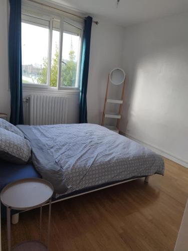 une chambre avec un lit, une chaise et une fenêtre dans l'établissement Cozy House, à Angers