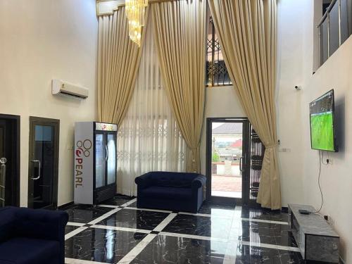 a lobby with a blue chair and a door with curtains at Whispering Hearts Guest House in Bortianor