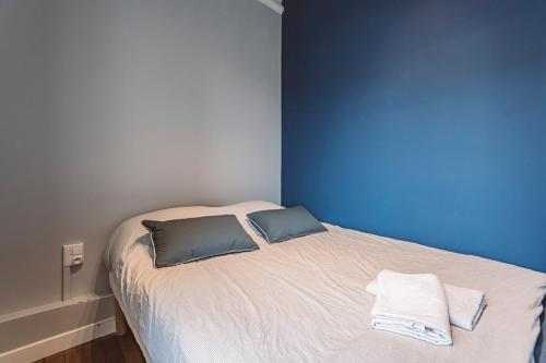 une chambre avec un lit avec deux oreillers dessus dans l'établissement Le Méditerranéen, face à la Cathédrale - 2D, à Reims