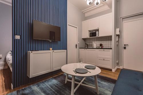 une pièce avec une table et une télévision sur un mur dans l'établissement Le Méditerranéen, face à la Cathédrale - 2D, à Reims