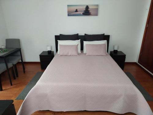 a bedroom with a large bed with pink pillows at Retiro das Camélias 2 in Lajes das Flores