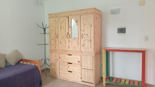 a wooden cabinet in a bedroom with a bed at Monoambiente in Morón