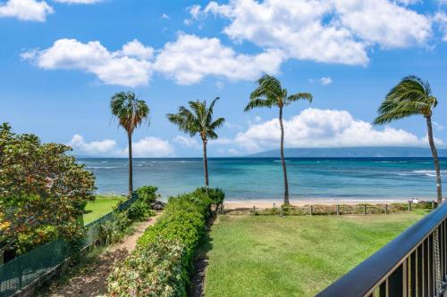 a view of the ocean from a balcony with palm trees at Kahana Village 2 · KHV 2 Direct Oceanfront 2BD Condo Steps to Be in Kahana