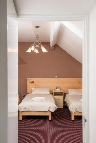 a bedroom with two beds and a chandelier at Rewley House University of Oxford in Oxford