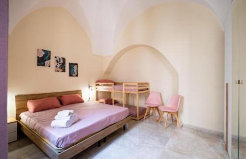 a bedroom with a bed and two pink chairs at White Sand in Gallipoli