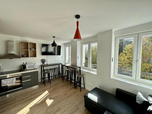 une cuisine et un salon avec un canapé et une table dans l'établissement Petra - Le confort à portée de main, à Reims