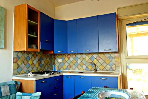 una cucina con armadi blu e tavolo di Casa Panoramica a Marettimo