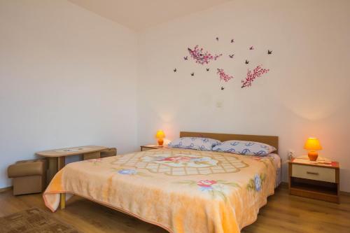 a bedroom with a bed with butterflies on the wall at Apartments Villa Luciana in Rijeka