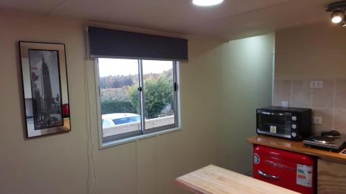 a small kitchen with a window and a microwave at Departamento en Quiriyuca in Puchuncaví
