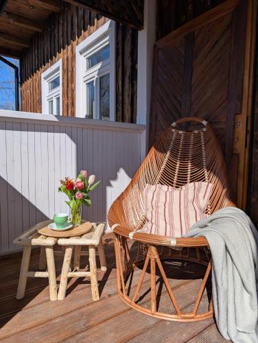a hammock chair on a porch with a table at Płachtówka in Słupia