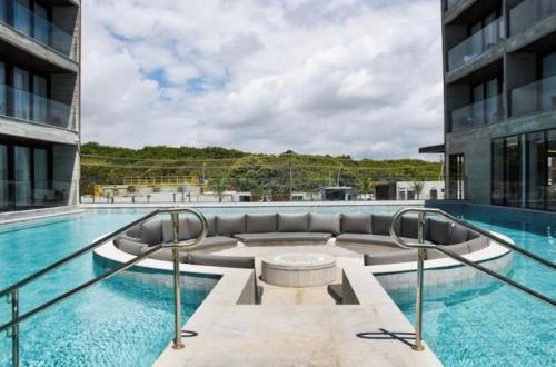 a swimming pool with a couch in the middle of a building at Porto Alto Gav Resorts in Porto De Galinhas