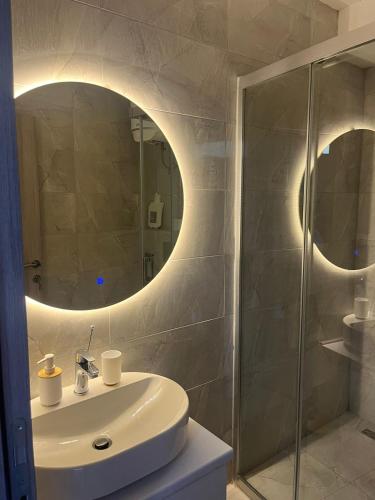 a bathroom with a sink and a shower with a mirror at FREE PARKING City Square Vanilla Apart-Hotel in Skopje