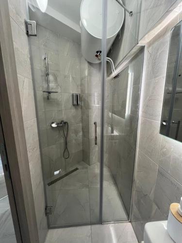 a shower with a glass door in a bathroom at FREE PARKING City Square Vanilla Apart-Hotel in Skopje