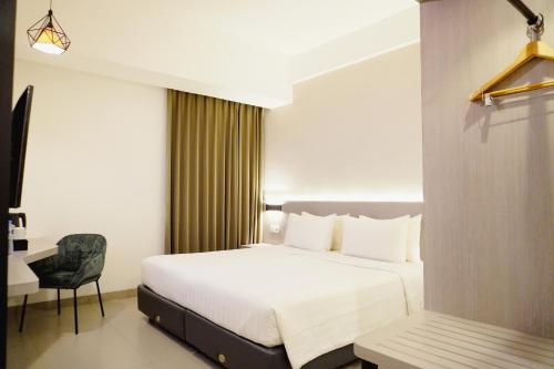 a hotel room with a bed and a chair at Laska Hotel Subang in Subang
