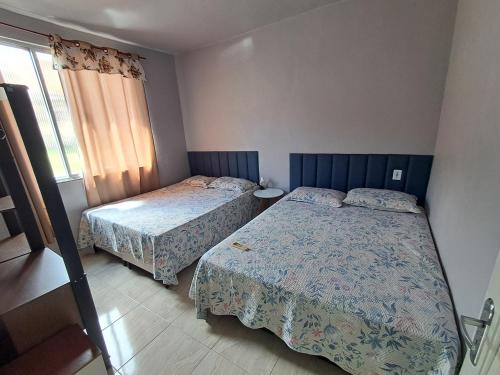 a bedroom with two beds and a window at Casa com 2 Camas Queen e 1 King em Quartos Climatizados in Rio de Janeiro