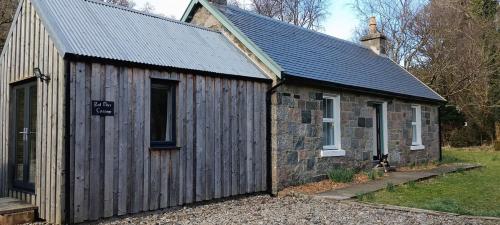 a small wooden building with a slate roof at Red Deer Cottage at Fanans in Oban