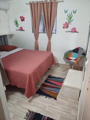 a bedroom with a red bed and a chair at Charmant appart in Fort-de-France
