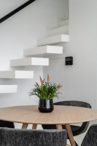 a wooden table with a potted plant on top of it at The White Loft - Cretan Luxury in Ierápetra