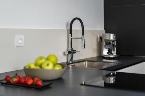 a kitchen counter with a bowl of apples and a sink at The White Loft - Cretan Luxury in Ierápetra