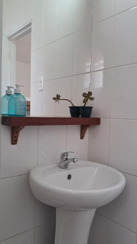 a white bathroom with a sink and a mirror at CasaValparaluz in Valparaíso