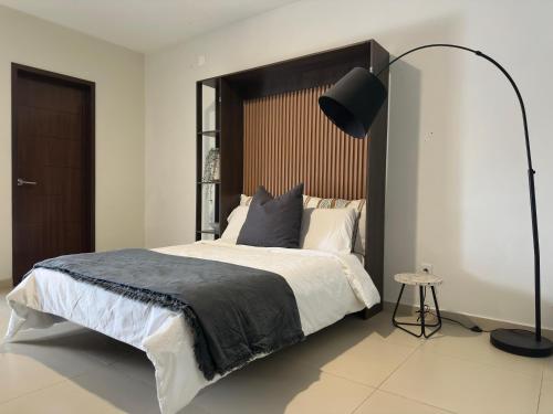 a bedroom with a large bed and a black lamp at Departamento zona EXPO GDL con Aire Acondicionado in Guadalajara