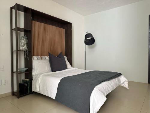 a bedroom with a large bed and a black lamp at Departamento zona EXPO GDL in Guadalajara