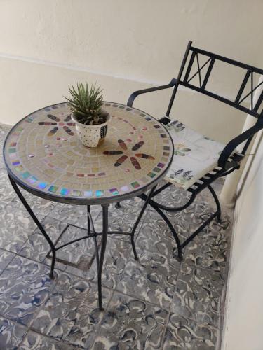 a table and a chair with a potted plant on it at Shanti Loft in San Juan