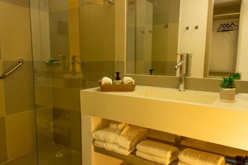 a bathroom with a sink and a mirror and towels at VVC Hotel's in Villavicencio