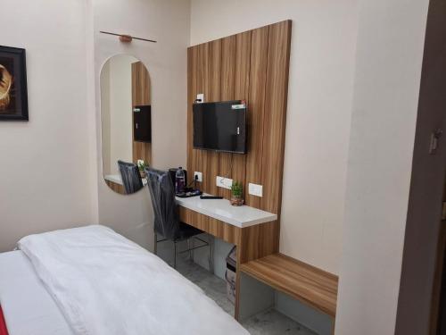a hotel room with a desk with a tv and a bed at Raghav Vilas - Essence of Kashi in Varanasi