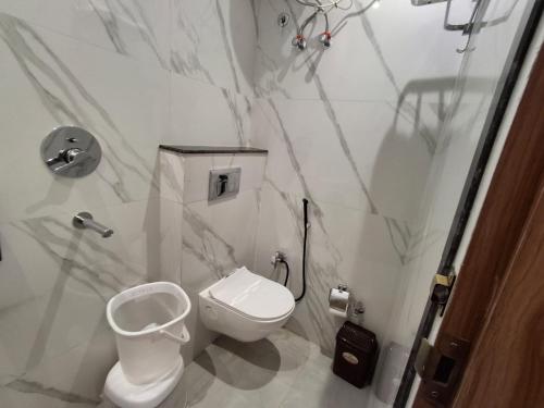 a white bathroom with a toilet and a sink at Raghav Vilas - Essence of Kashi in Varanasi