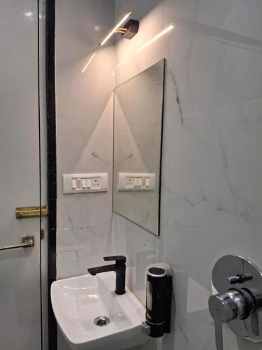 a white bathroom with a sink and a mirror at Raghav Vilas - Essence of Kashi in Varanasi