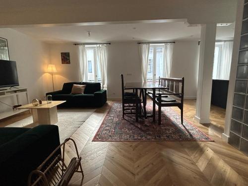 un salon avec une table, des chaises et un canapé dans l'établissement Charming fully renovated flat in old-town, à Ferney-Voltaire