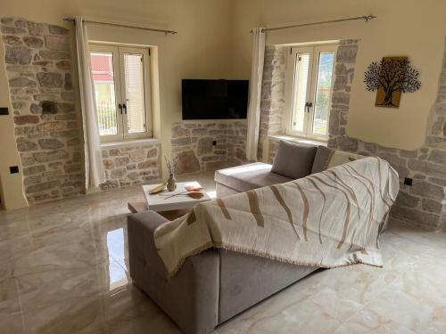 a living room with a couch and a tv at Mythic Gem in Vathi, Ithaka