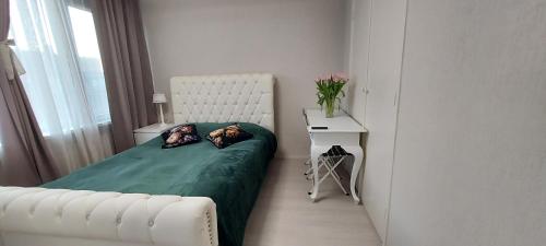 a small bedroom with a bed and a white chair at Cozy room in host house near Rotterdam in Maassluis