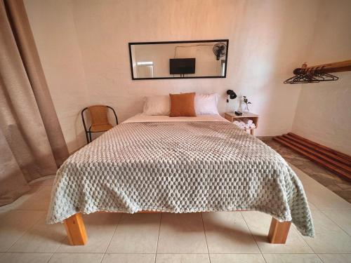 a bedroom with a bed with a blanket and a mirror at Elena Coffee Hostel Lago Calima Darién in Darién