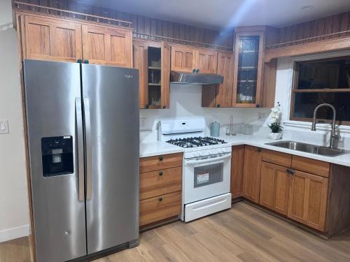 a kitchen with a stainless steel refrigerator and wooden cabinets at Modern Bedroom in Long Beach 1 in Long Beach
