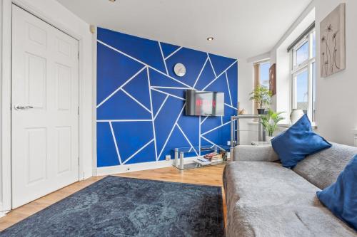 a living room with a couch and a blue wall at Spacious 1 Bedroom Apartment in Birmingham
