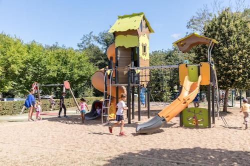 un groupe d'enfants jouant sur une aire de jeux dans l'établissement Camping Saint Avit Loisirs, à Journiac