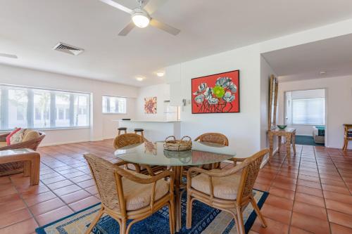 a dining room and living room with a table and chairs at Balboa Apartments in Port Douglas