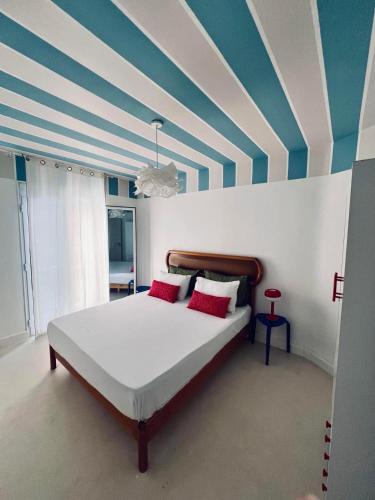a bedroom with a bed with a striped ceiling at Le Nid Des Couleurs in 'Aïn Taya