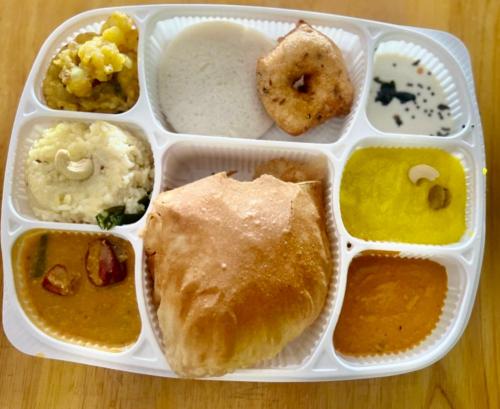 a styrofoam lunch box with various foods in it at La Bay Luxury Beach Bungalow in Puducherry