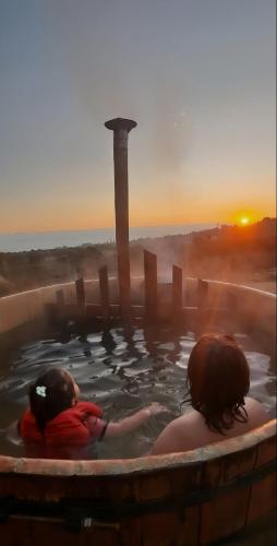two children swimming in a hot tub with the sunset at Algarrobo Tinaja Caliente Privada Lista para Disfrutar in Tunquen
