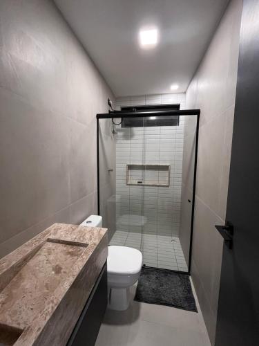 a bathroom with a shower with a toilet and a sink at Flat aconchegante à 300m do mar! in Cabedelo