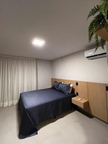 a bedroom with a bed and a potted plant at Flat aconchegante à 300m do mar! in Cabedelo