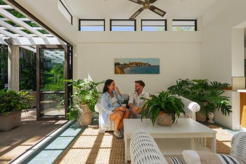 a man and woman sitting on the porch of a house at Emerald Inn on Takapuna Beach in Auckland